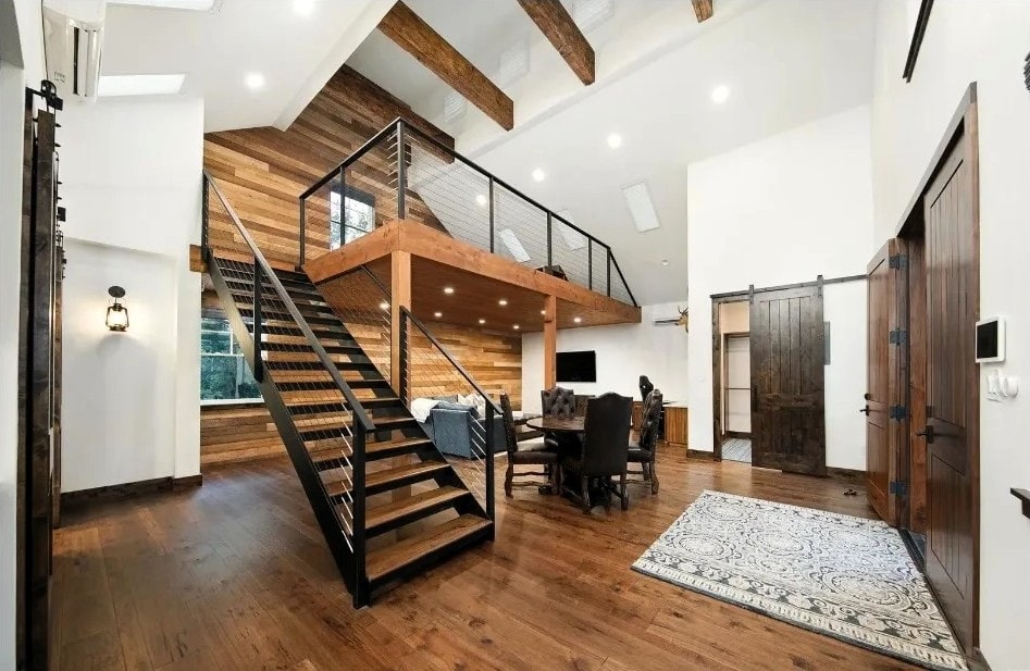 Open loft interior with wood-clad walls and steel staircase