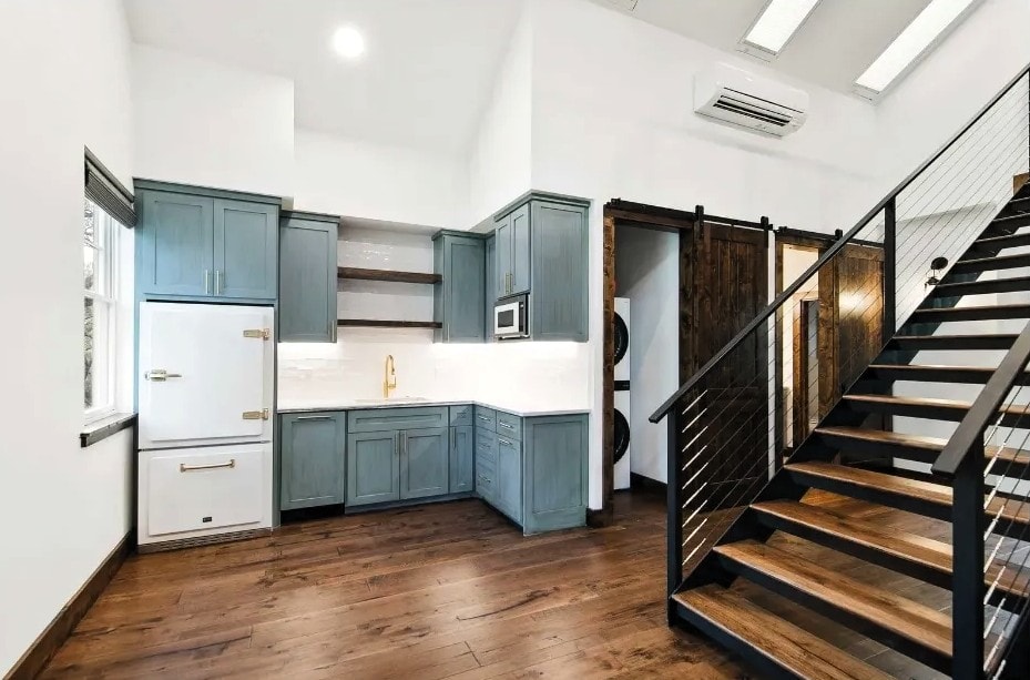 Teal kitchen with gold fixtures and barn door